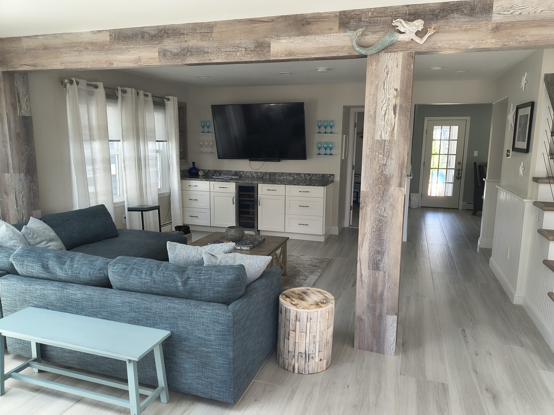Open living room with blue sectional and driftwood-style beams
