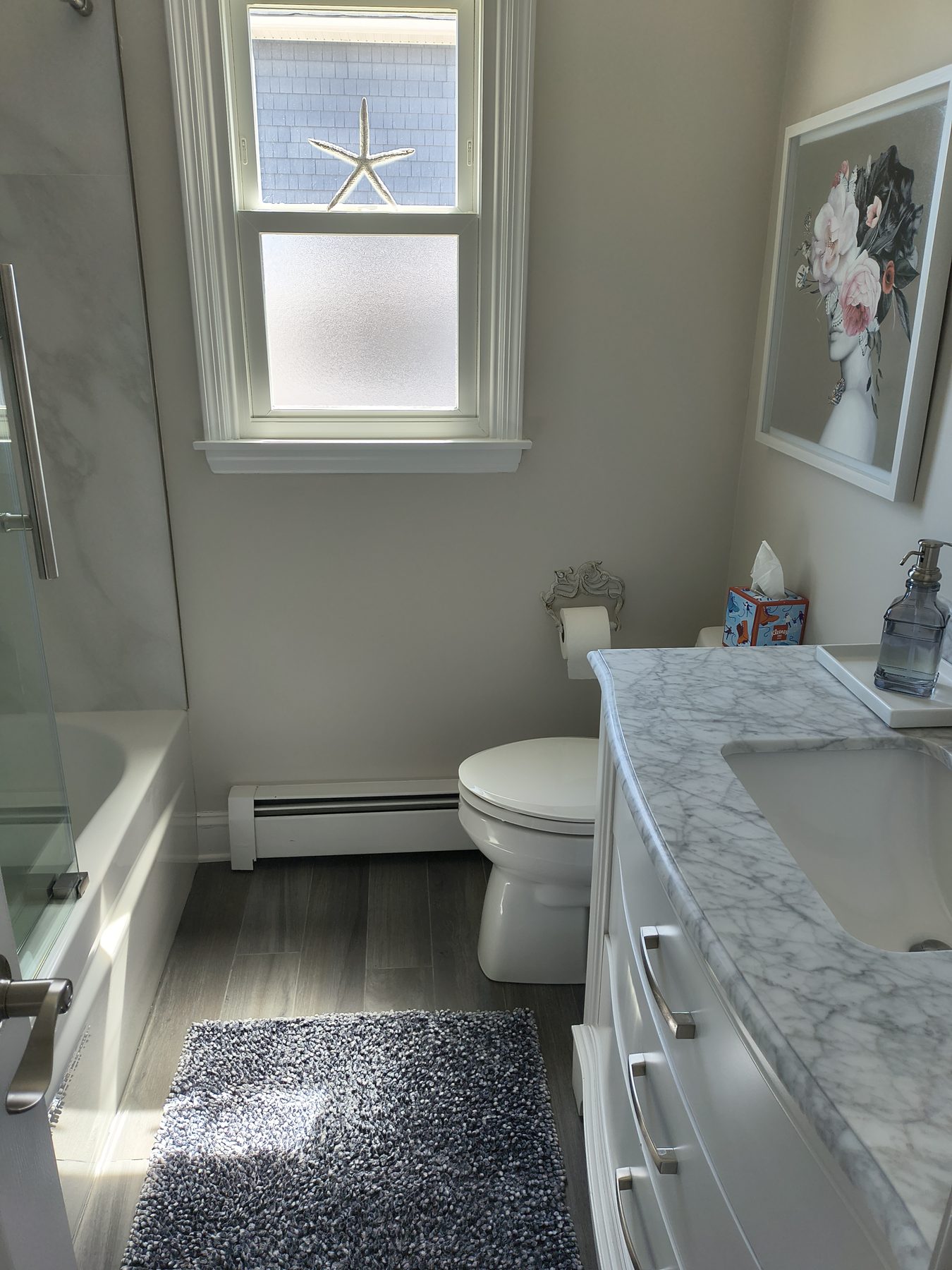 Carrara marble bathroom with starfish in window