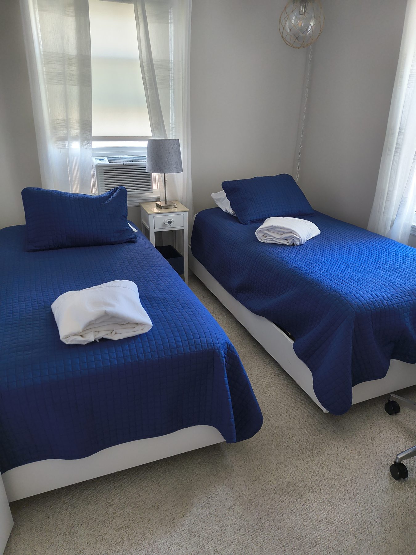 Twin beds with bright blue quilts