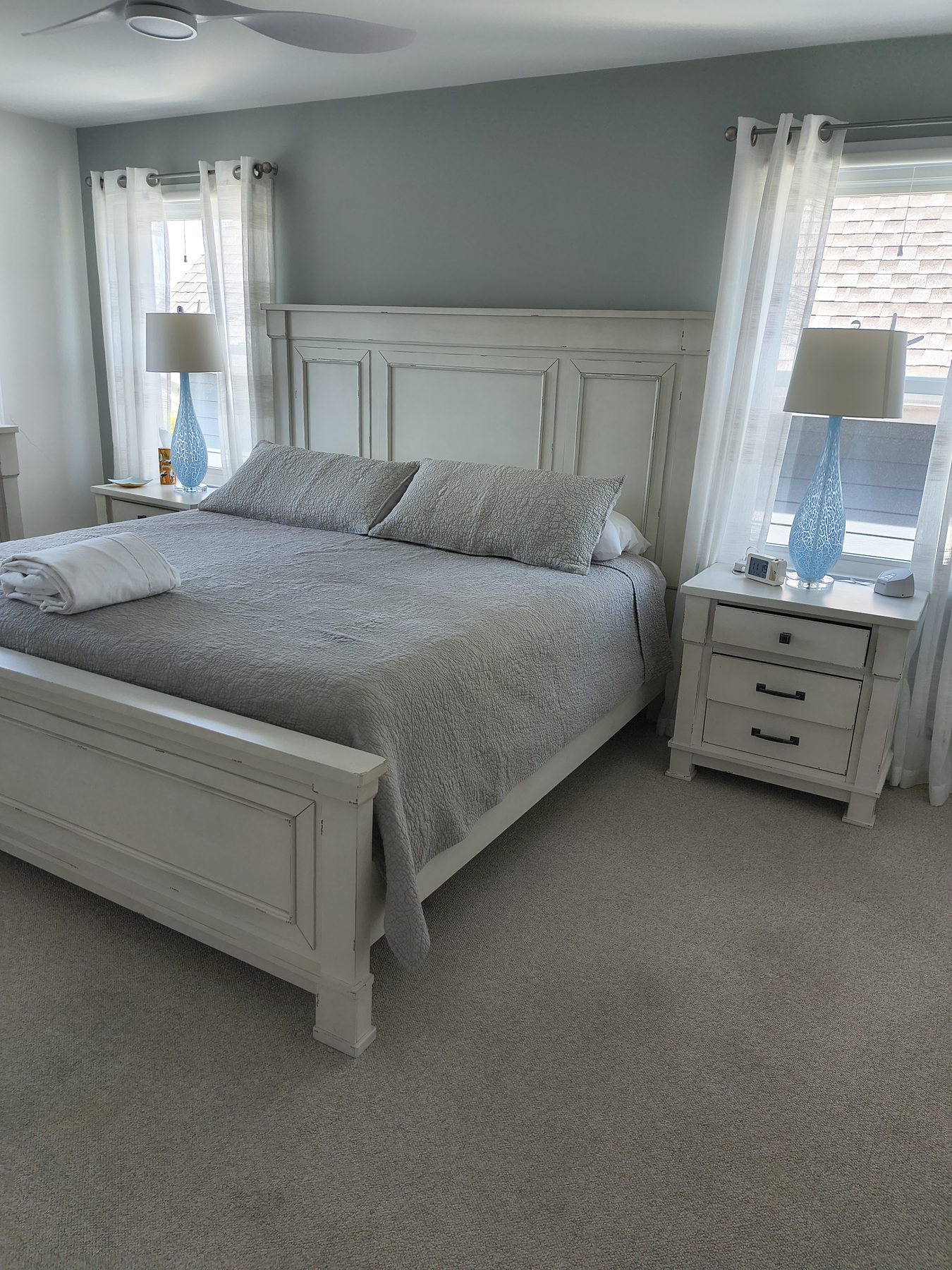 Bedroom with white quilt and vintage white headboard