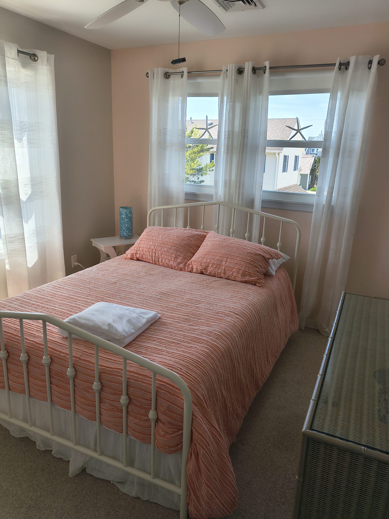 Bedroom with peach quilt and iron bed frame