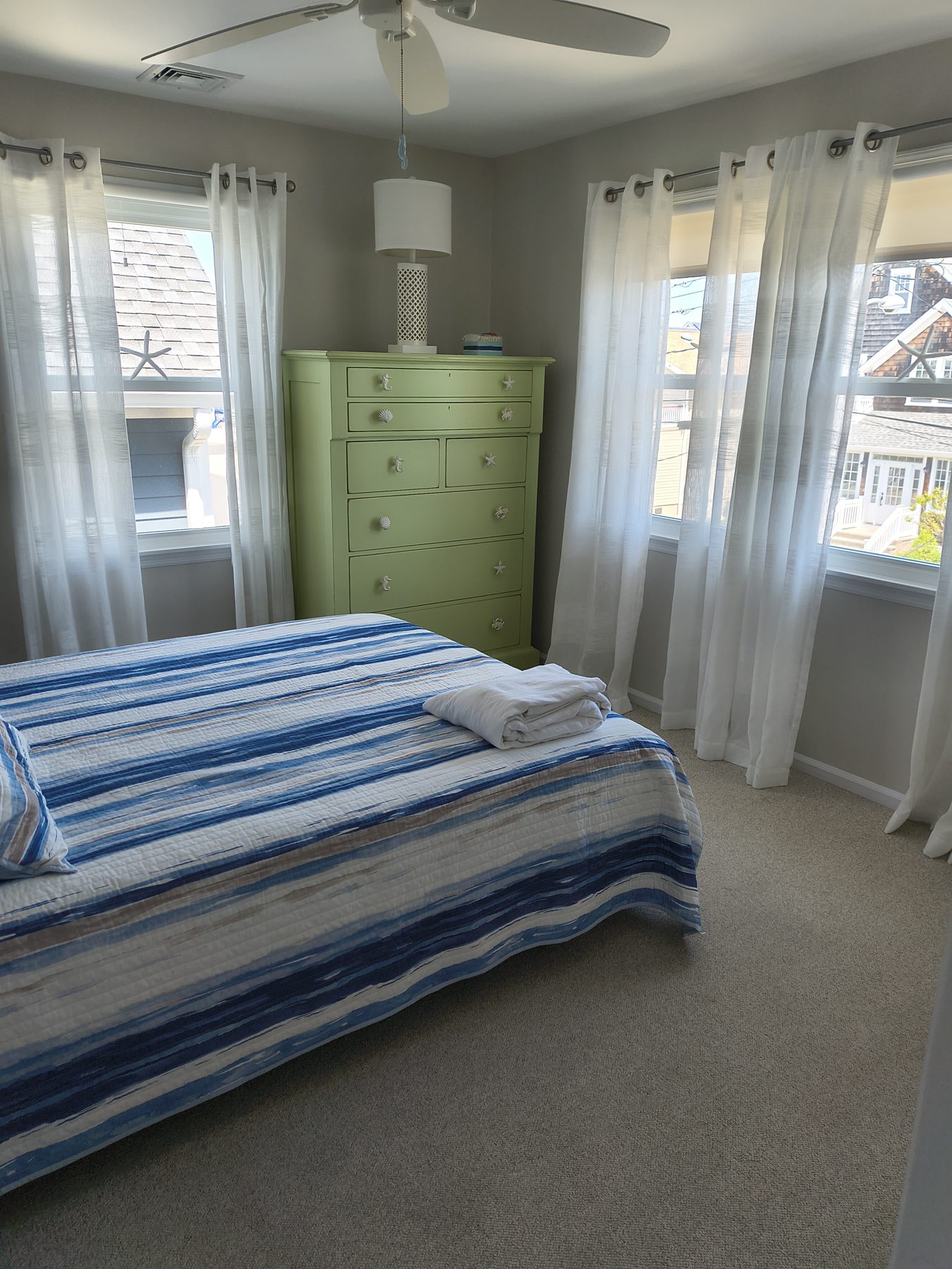 Bedroom with blue-striped bedding and green dresser