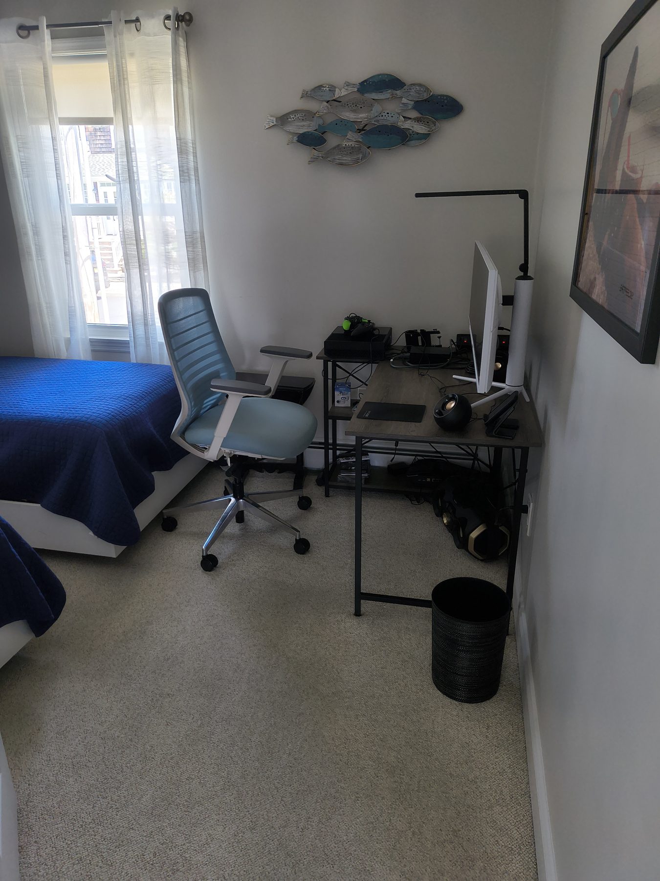 Office nook inside a bedroom with desk, monitor, and twin bed