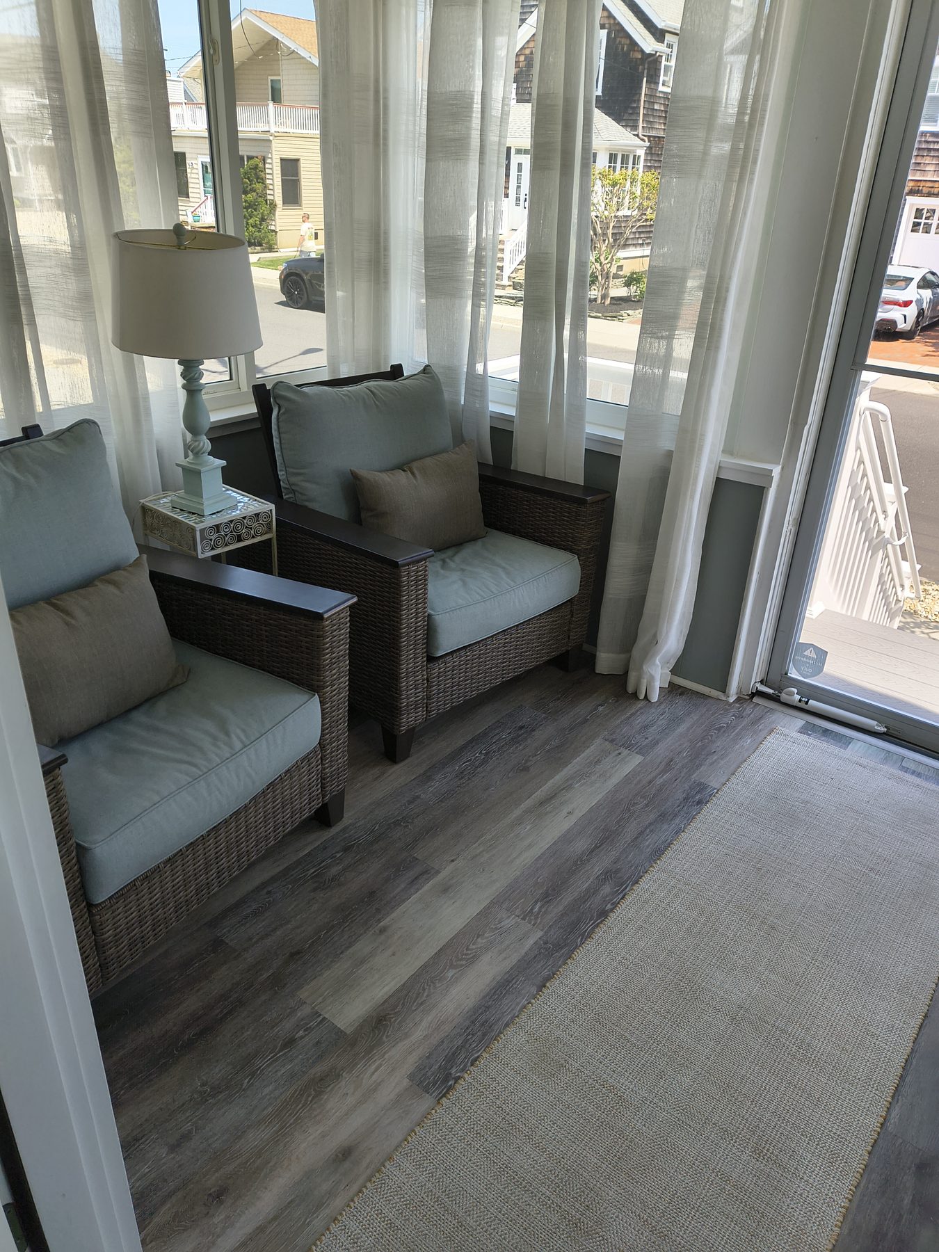 Sunroom with wicker chairs and lamp between